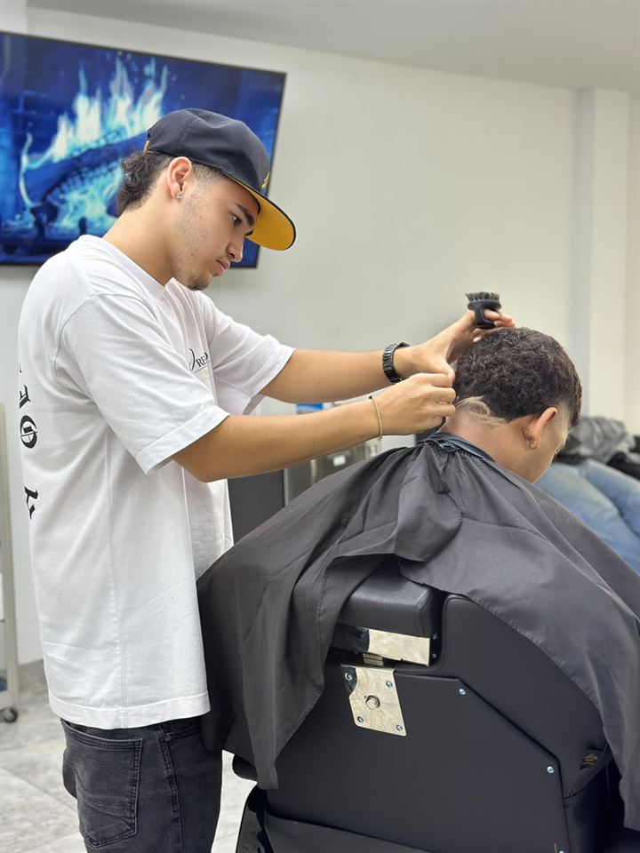 Andres Sarria realizando un corte rizado en Prestigio Barberia.